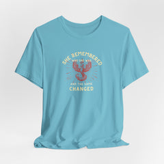 Women's Motivational Quote Tee - Red Phoenix by Doctor T-shirt Studio featuring a red phoenix graphic on a turquoise shirt, symbolizing strength and inspiration.